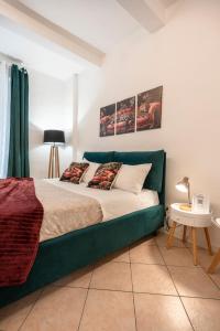 a bedroom with a bed with a green couch at T'amo House in Macerata +11 photos