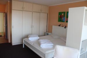 a bedroom with a white bed with white cabinets at Fereinwohnung an der Ostsee E310 in Brasilien
