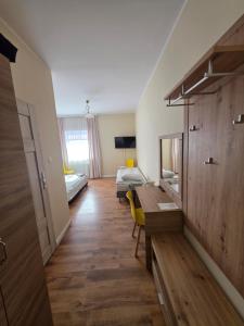 ein Zimmer mit Schreibtisch und Bett und ein Schlafzimmer in der Unterkunft W Dolinie in Działdowo