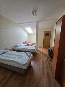 ein Zimmer mit zwei Betten und einem Stuhl in der Unterkunft W Dolinie in Działdowo
