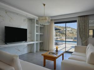 a living room with a tv and a couch and a table at Villa Christy in Psarou