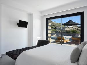 a bedroom with a bed and a view of a patio at Villa Christy in Psarou +40 photos