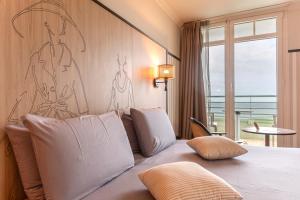 a bedroom with a bed with a large window at Mercure Granville Le Grand Large in Granville +177 photos