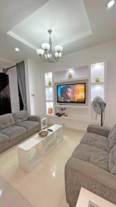 a living room with two couches and a flat screen tv at 3Apartments in Lagos
