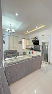 a living room with a couch and a kitchen at 3Apartments in Lagos