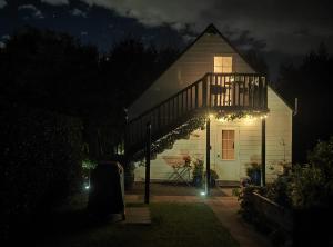 a house lit up at night with christmas lights at Cosy Orchard Loft - Fast WIFI in Tauranga