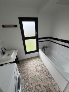 a bathroom with a tub and a toilet and a sink at Côte Saint-Pierre in Ambleteuse