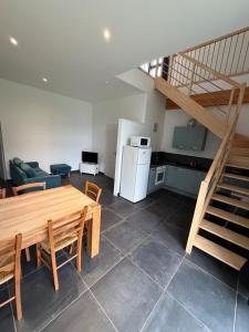 a living room with a wooden table and a staircase at Côte Saint-Pierre in Ambleteuse
