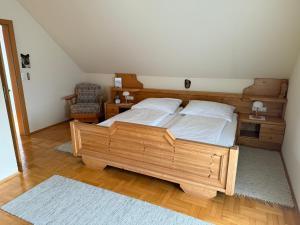 a bedroom with a wooden bed and a chair at Haus am Ring in Spielberg