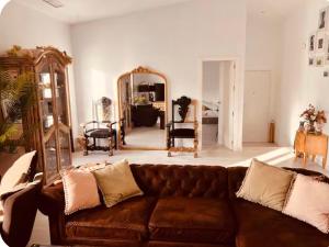 a living room with a brown couch and a mirror at Casa de la luz in Cartagena
