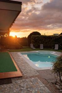 a swimming pool with a sunset in the background at Ca' del Maharajà in Gargallo