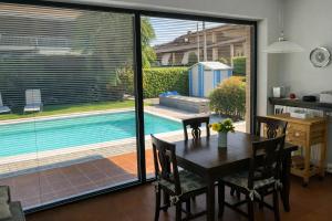 a dining room with a table and a view of a pool at Ca' del Maharajà in Gargallo