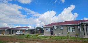 a row of houses with a car parked in front at Phelelani Lodge Jozini in Jozini