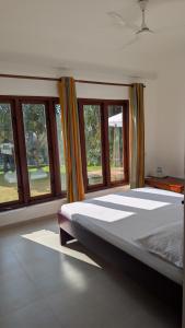 a bed in a room with windows in it at Alpha bungalow in Kandy