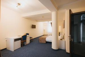 a hotel room with a bed and a desk at Vila Turistică Fabian in Botoşani +35 photos