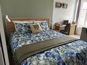 a bedroom with a bed with a colorful comforter at Ar Gwennili Chambres d'Hôtes in Saint-Amant-de-Nouère