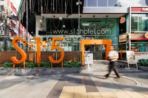 a person walking down a street in front of a building at S15 Sukhumvit Hotel in Bangkok