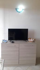 a flat screen tv sitting on top of a dresser at Badesi Apartment - Mirto in Badesi