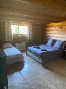 a bedroom with two beds in a log cabin at Casa Laricciu in Figari