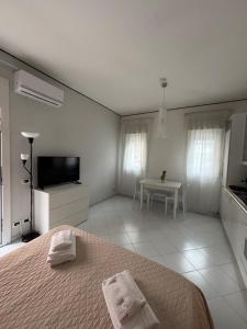 a white bedroom with a bed and a table at Rael in Cefalù