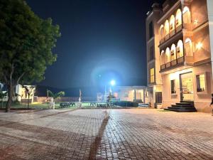 a cobblestone street in front of a building at night at Eco Fort Hotel and Resort in Mahwah