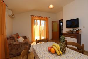 ein Wohnzimmer mit einem Tisch und Obst darauf in der Unterkunft Apartment in Silo/Insel Krk 14534 in Polje