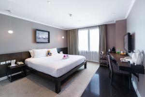 a hotel room with a bed and a desk at S15 Sukhumvit Hotel in Bangkok