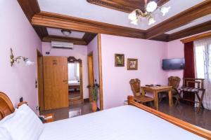 a bedroom with a bed and a desk and a table at Brilant Antik Center in Tirana