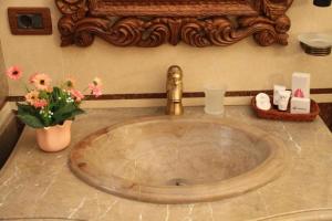 a bathroom sink with a gold faucet and flowers at Brilant Antik Center in Tirana +65 photos