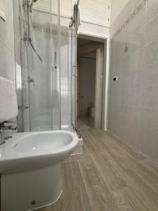 a white bathroom with a shower and a sink at Rael in Cefalù