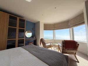 a bedroom with a bed and a room with a view at Housel Bay Hotel in Lizard