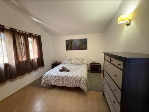 a bedroom with a bed and a dresser at Los Canteros de Belgara - Atlantic View Retreat in Frontera