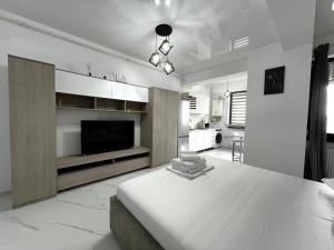 a white bedroom with a large bed and a flat screen tv at Mamaia-NordCom Apartamente Exclusiviste S Resort 1 CBN la plaja Azimuth in Mamaia Sat/Năvodari
