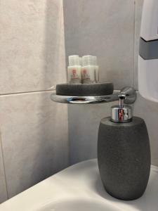 a bathroom with a soap dispenser on top of a toilet at Rael in Cefalù