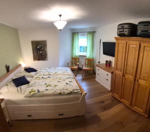 a bedroom with a bed and a dresser and a television at HOME4GOLF Uttlau in Bad Griesbach