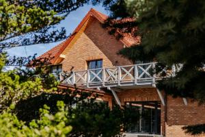 a brick house with a balcony on the side of it at Marina Piaski Apartamenty in Piaski