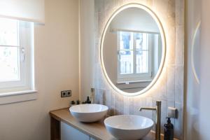 a bathroom with two white sinks and a mirror at Boutique Charme Apartments Küferstr 10-12 in Baden-Baden +30 photos