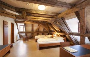 two beds in a room with wooden ceilings at Gäste- und Tagungshaus Benediktinerabtei Plankstetten in Berching