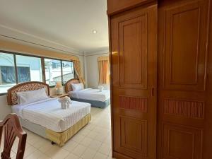 a bedroom with two beds and a door to a room at Baan Smile in Patong Beach +48 photos