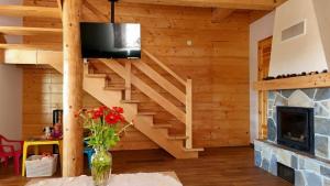 a living room with a staircase and a fireplace at Dom u Braci in Wołkowyja