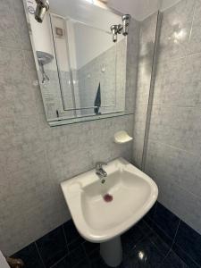 a bathroom with a sink and a mirror at Seaside Paralio Apartment in Astros