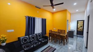 a living room with yellow walls and a couch and a table at Moms homestay 3 Bedrooms in Vagamon
