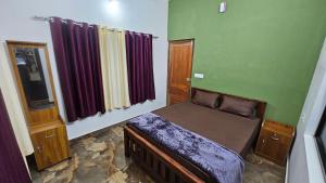 a bedroom with a bed in a green room at Moms homestay 3 Bedrooms in Vagamon