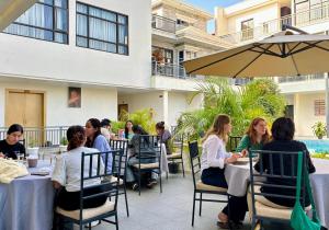 Eine Gruppe von Menschen sitzt an Tischen in einem Restaurant in der Unterkunft Hotel Gulmohar in Bharatpur