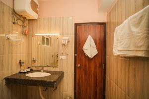 a bathroom with a sink and a wooden door at Verdant The Vintage in Lachung +23 photos