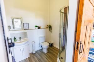 a bathroom with a toilet and a sink at Modern Barn Conversion in Brackley