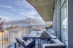 a balcony with a table and chairs and a view of the water at Le Saphir - Vue panoramique sur le lac d'Annecy in Annecy