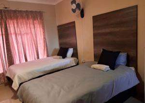 two beds sitting next to each other in a bedroom at Amatis House in Mokopane
