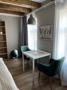 a room with a table and two chairs and a bed at A33 central studio aparthotel in Liepāja