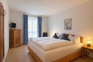 a bedroom with a large bed and a window at Tivoli Apartments in Bad Reichenhall